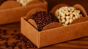 Imagem ilustrativa de uma caixa com brigadeiro gourmet sobre uma mesa marrom e com granulados espalhados